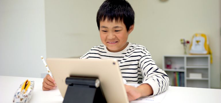 テキストに英語の文字を書こうとしている子供の写真