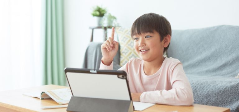 タブレットに向かって話しかけている男の子