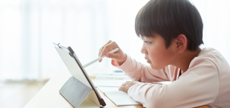 テキストに英語の文字を書こうとしている子供の写真