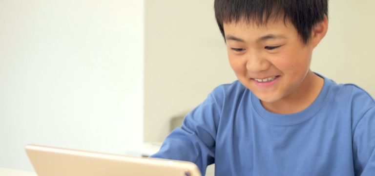 テキストに英語の文字を書こうとしている子供の写真