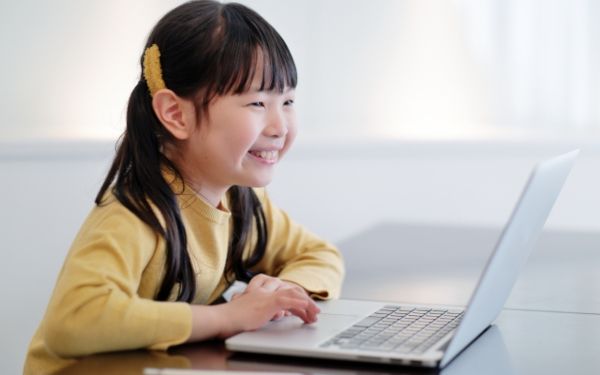 ノートパソコンを見ながら笑う女の子