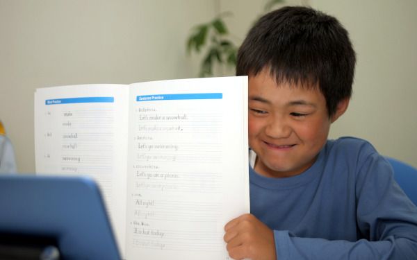 タブレットにレプトンのテキストを見せながら笑う男の子