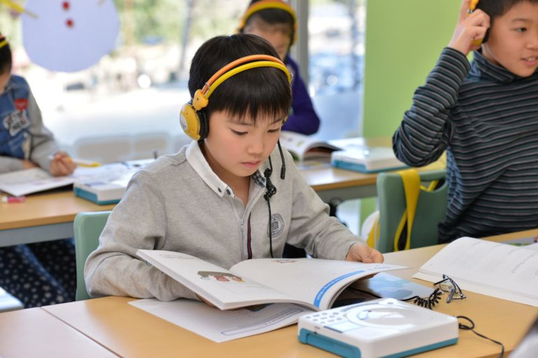 子どもが英語のテキストを読むイメージ